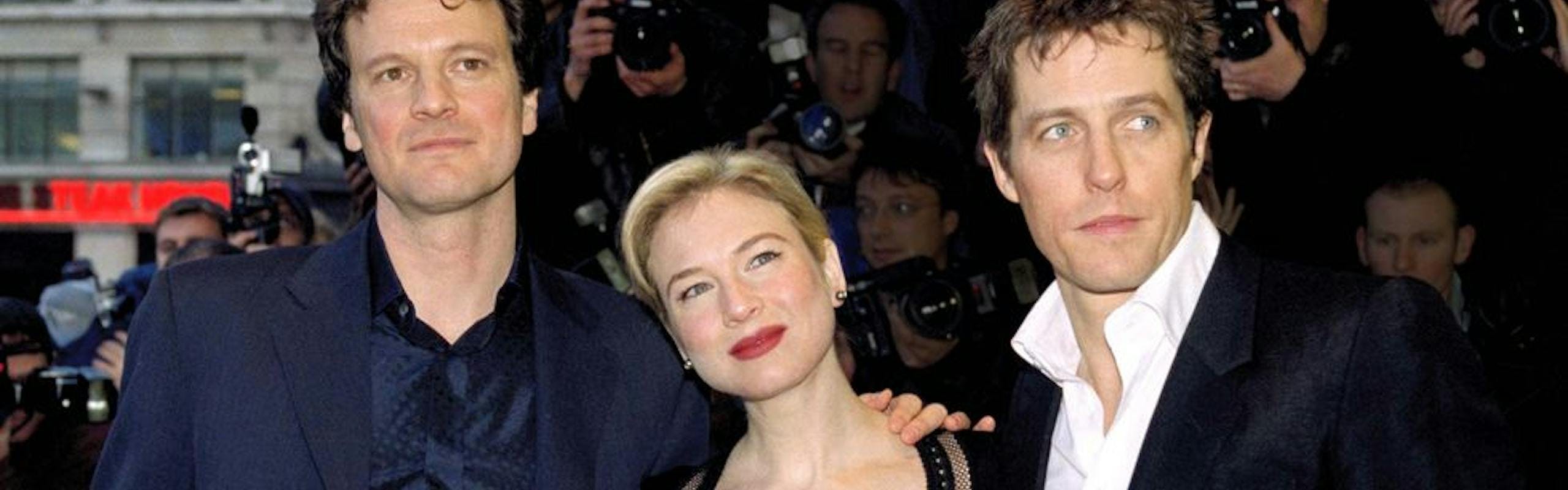 Colin Firth, Renée Zellweger, and Hugh Grant pose for a photo on a red carpet together