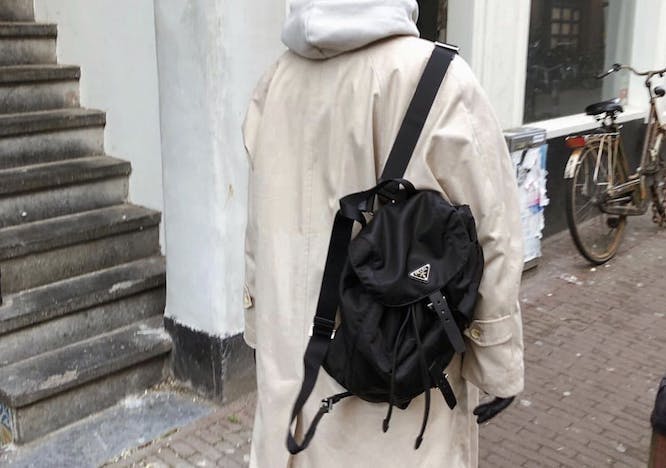 woman carrying a prada backpack